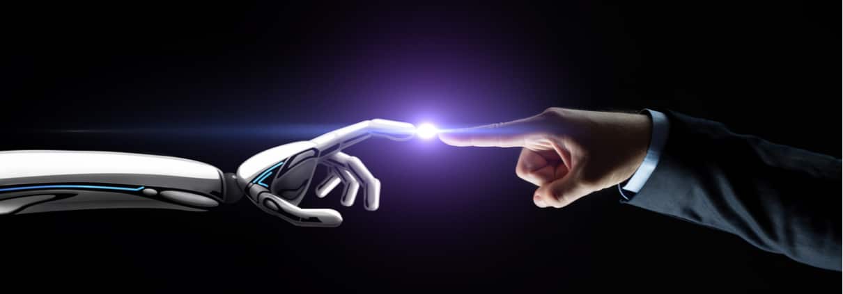 Robot hand and human hand touching a dot of light in the middle of them