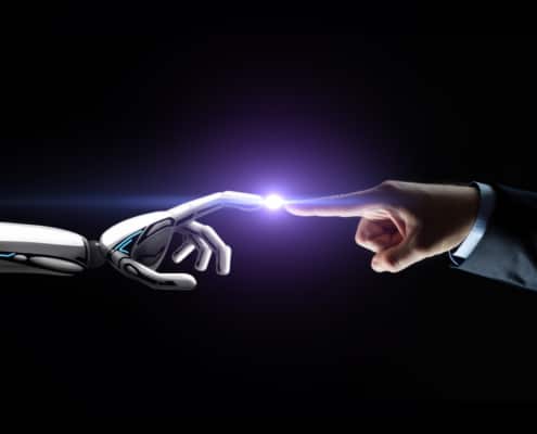 Robot hand and human hand touching a dot of light in the middle of them