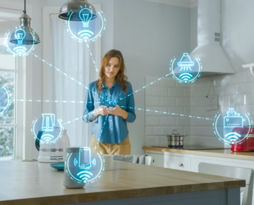 Woman standing in a kitchen with hologram icons coming from her phone depicting the Internet of Things