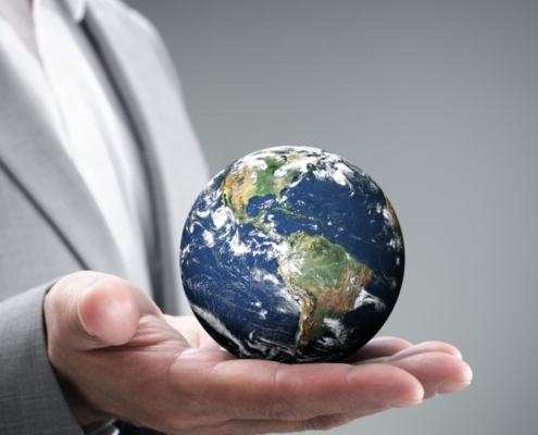 Businessman holding the world in the palm of hands concept for global business, communications, politics or environmental conservation Earth image courtesy of Nasa