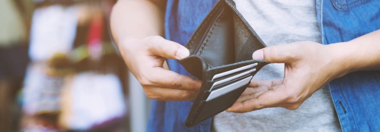 close up man person holding an empty wallet in the hands of an man no money out of pocket in front of the shop store. No money to pay shopping purchase Sell or Payment.